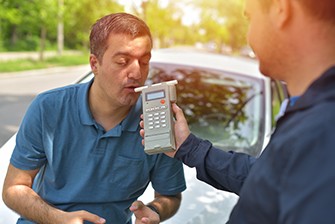 What is Blood Alcohol Concentration? Man blowing in a machine to test blood alcohol concentration.