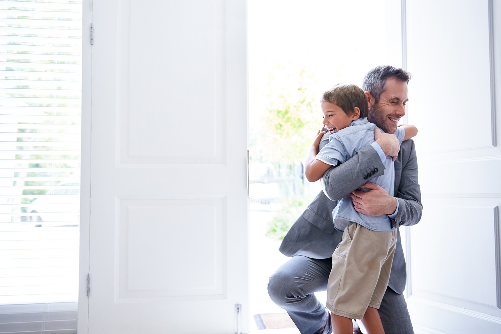 Mindsight & Interpersonal Neurobiology, a man hugging his son in a bright room.