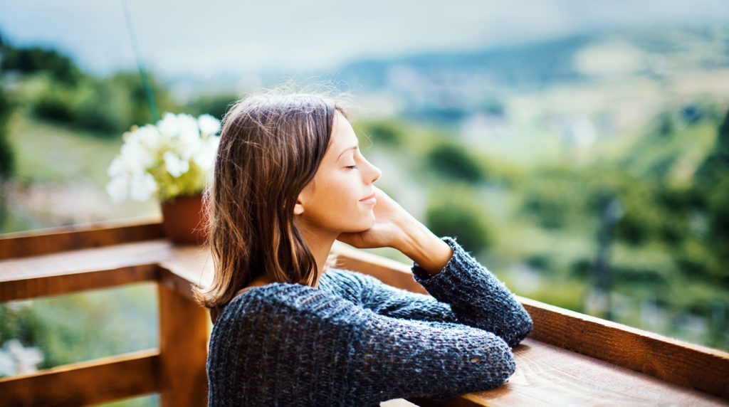 Cliffside Malibu natural surroundings, woman looking off of the deck.