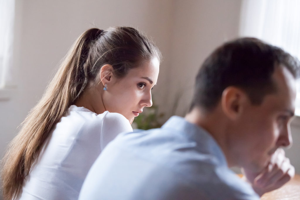 Brunette woman looking at man, thinking about overcoming addiction.