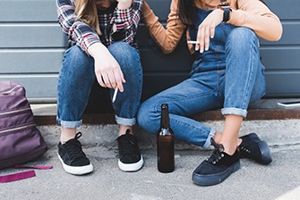 Substance Use Disorder in Adolescence, two teens sitting on the curb.