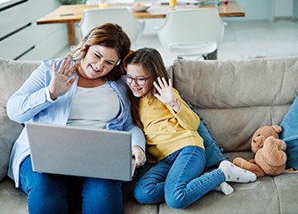 Coronavirus: Difference Between Quarantine, Isolation, and Social Distancing, mom and child on video call on laptop.