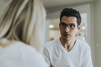 Why People Aren't Talking About Substance Use Disorder, man talking to woman in white shirt and glasses.