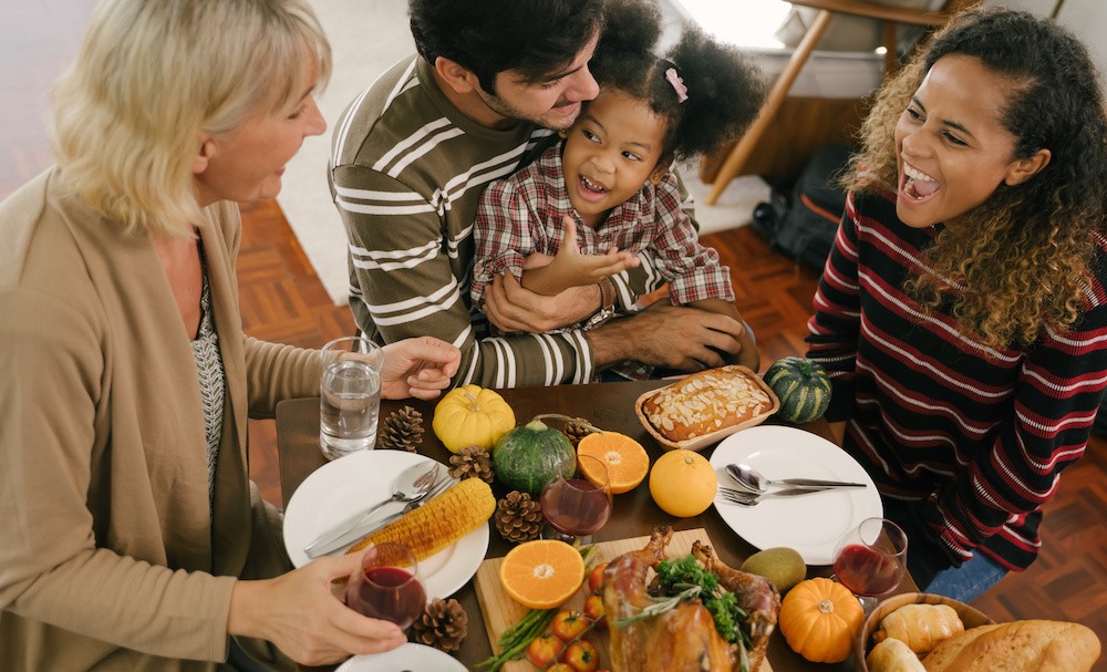 Family around a thanksgiving diner table, talking about how to have a happy healthy and sober holiday.