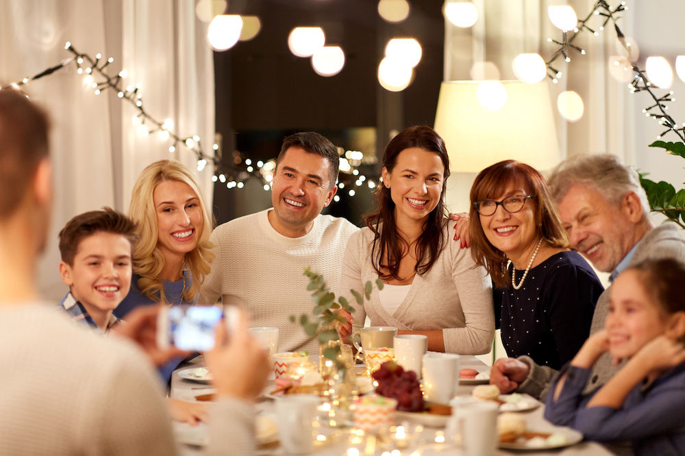 Group family photo around the dinner table, sober holidays with friends and family.