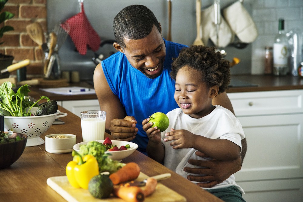 A man and child in the kitchen with healthy food, good nutrition helping with addiction recovery.