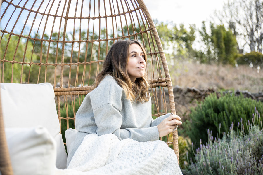 Woman sitting in chair outside thinking, you are not your addiction.