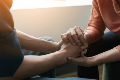 Two people holding hands and supporting each other