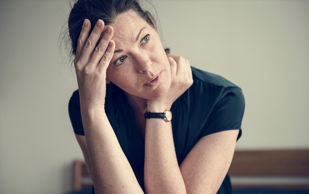 Woman deciding is she is ready for treatment yet, wearing a black tshirt.