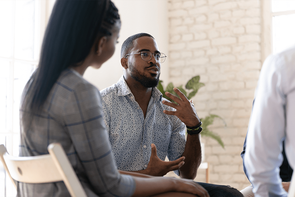 Man talking in group therapy about how to make addiction treatment work for you.