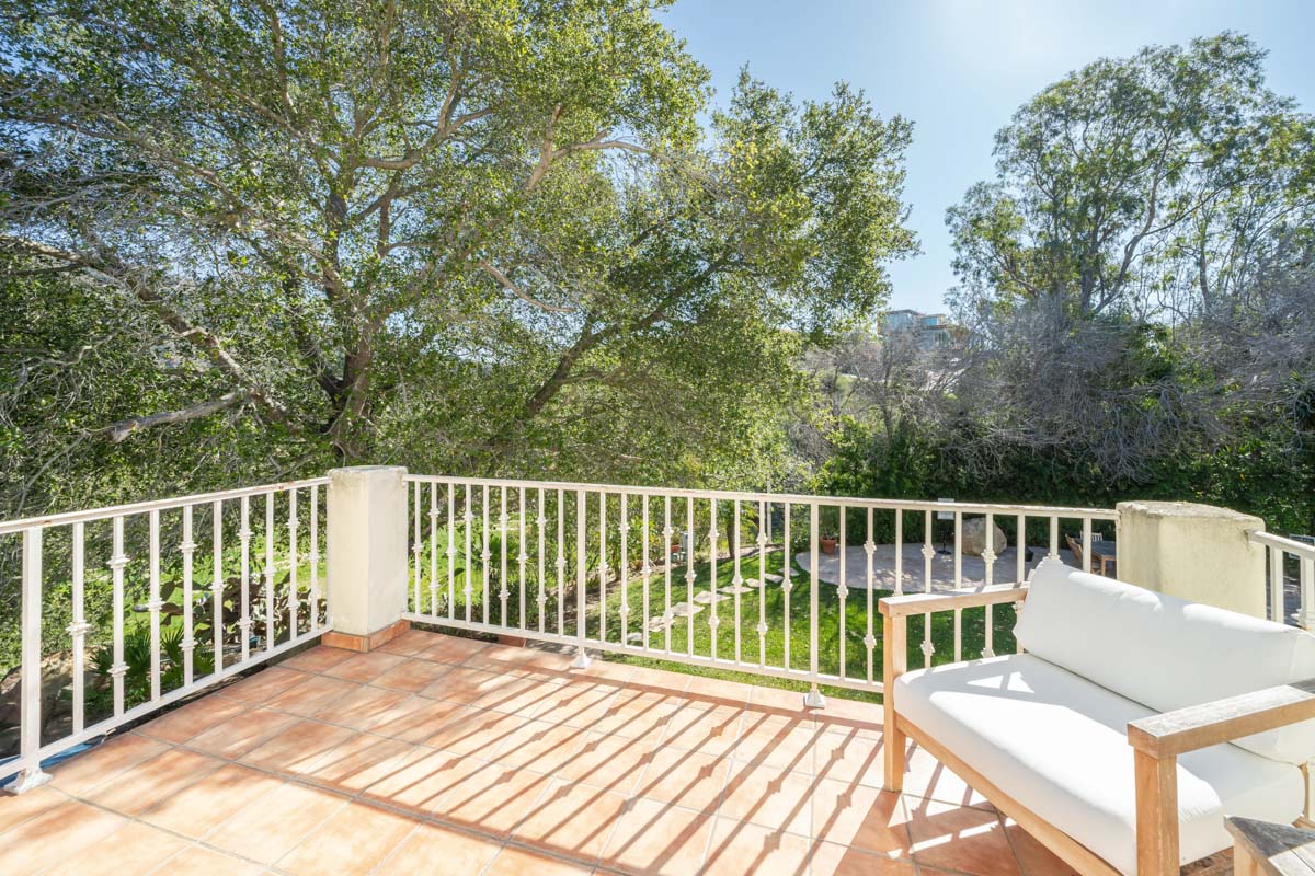 View of the deck at Cliffside Malibu, a residential treatment center in Malibu, California. A deck with white trim and a wooden bench with white cushions.