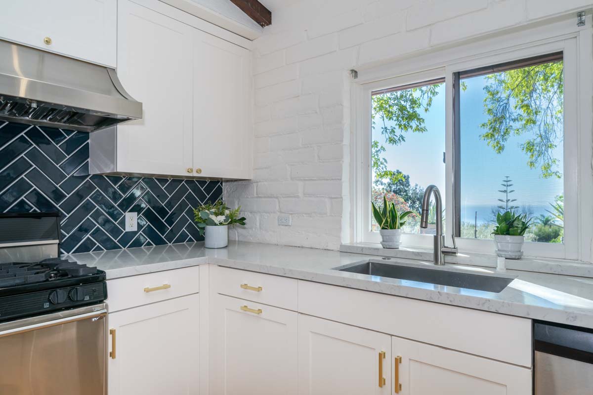 View from the kitchen with blue tiled backsplash and marble counter tops in Cliffside Malibu, in Malibu, California.