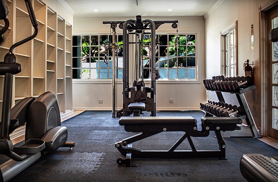 Gym fitness room with machines and black grip flooring in the Sunset Malibu, residential treatment center in Malibu, California.