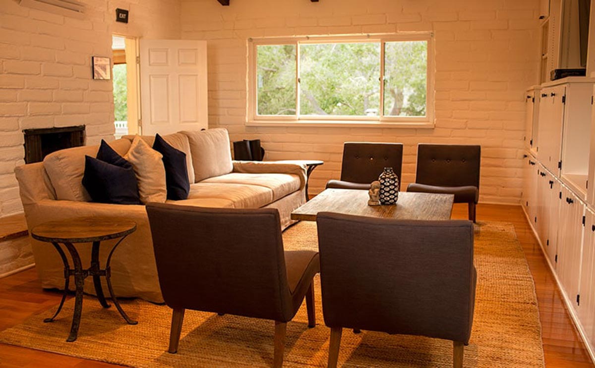 Living room in Cliffside Malibu, residential treatment house. Couch and chairs around a table in Malibu, California.