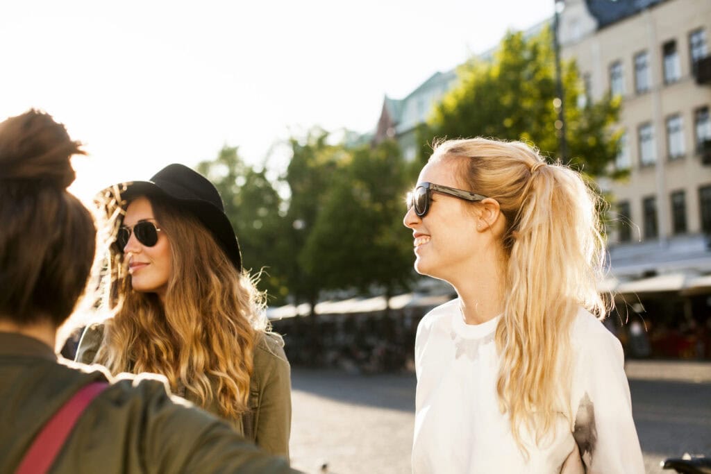 Happy woman standing with friends on city street